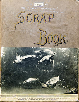 Image of front cover of Joan Procter's scrapbook about her appointment to London Zoo. 'Scrapbook' is handwritten in gold and black ink, and beneath it is a newspaper clipping image of turtles swimming.